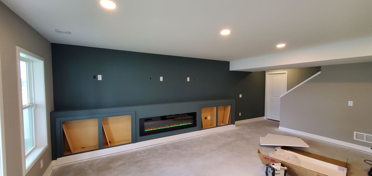 Empty living room with dark accent wall, fireplace, and recessed ceiling lights