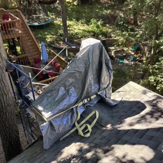 Covered stroller on a wooden deck in a wooded backyard