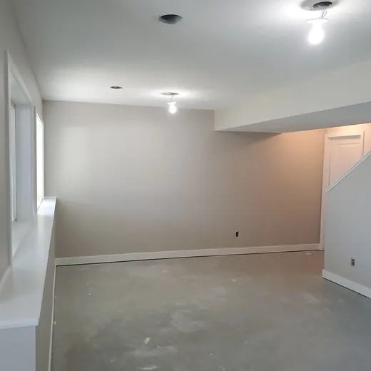 Empty beige room with unfinished floor and recessed ceiling lights