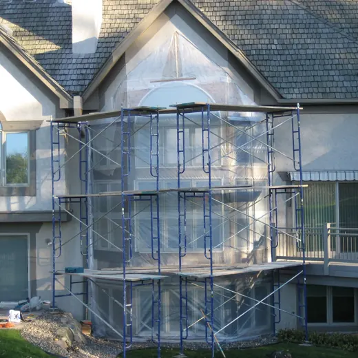 House exterior with metal scaffolding around the central entrance under construction
