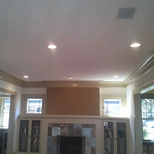 Living room with a stone fireplace, built-in cabinets, and recessed ceiling lights