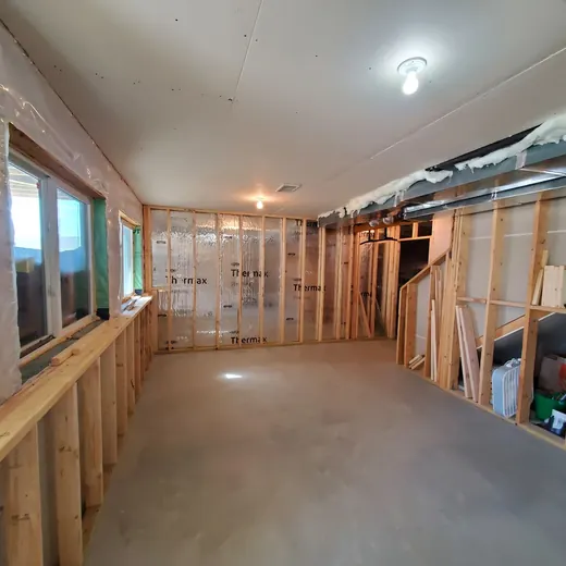 Partially renovated room with exposed studs, drywall, and a concrete floor under construction