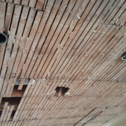 Wooden slatted ceiling with several recessed light fixtures and open rectangular cutouts